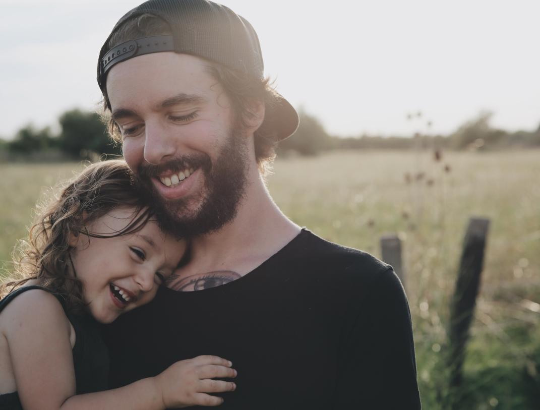 Papa en dochter Een vader die zijn dochter draagt en samen wandelen in de velden.